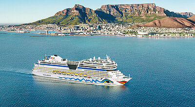 Kreuzfahrtschiff fährt vor der Kulisse Kapstadts mit Tafelberg