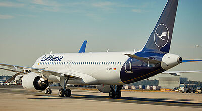Ein Flugzeug von Lufthansa des Typs Airbus A320 in weiß-blauer Lackierung rollt auf einer Start- und Landebahn eines Flughafens