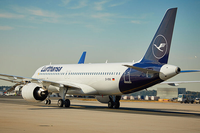 Ein Flugzeug von Lufthansa des Typs Airbus A320 in weiß-blauer Lackierung rollt auf einer Start- und Landebahn eines Flughafens