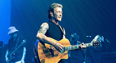 Peter Maffay und Band werden auf der Reise 2025 drei Konzerte geben Sänger Peter Maffay mit Gitarre auf Konzertbühne