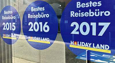 Plakative Eigenwerbung von Holiday Land: Die Kette vergibt seit Jahren den Titel „Bestes Reisebüro“