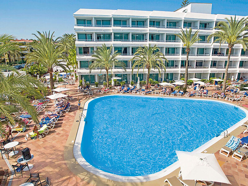Ein Pool umgeben von einem mehrstöckigen Hotel
