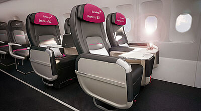 Rendering der neuen Business-Class-Sitze der Fluggesellschaft Eurowings in einer Flugzeugkabine, in der die Sonne hereinscheint.