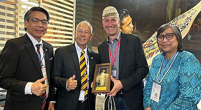Zwei männliche Touristiker und eine weibliche Touristikerin aus Sarawak auf der ITB in Berlin. Und ein deutscher Journalist