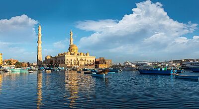 Moschee und Hafen in Hurghada, Ägypten, vor blauem Himmel