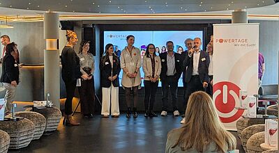 Vertreter von den sechs Partnern Arosa, Ameropa, Bentour, Chamäleon, Bentour, Chamäleon, NCL und Olimar präsentierten auf der Arosa Sena jede Menge Neuigkeite Gruppenaufnahme auf den Powertagen 2024 an Bord der Arosa Sena: Vertreterinnen und Vertreter der Partnerunternehmen – darunter Arosa, Ameropa, Bentour, Chamäleon, NCL und Olimar – stehen gemeinsam auf der Bühne und begrüßen die Teilnehmenden des Events.