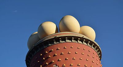 Detailansicht des Dalí-Theaters und -Museums in Figueres, Katalonien – charakteristische Fassade mit goldenen Dekorationen und überdimensionalen Eiern auf dem Dach, Wahrzeichen der Costa Brava und beliebtes Reiseziel für Kunst- und Kulturinteressierte.