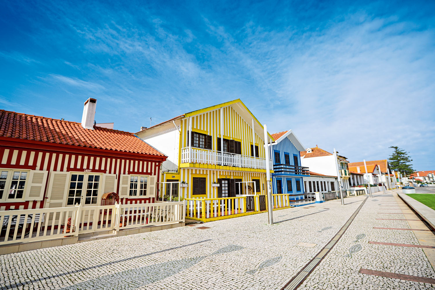 Toller Tagesausflug: Bonbonfarbene Holzhäuser an der Promenade der Costa Nova