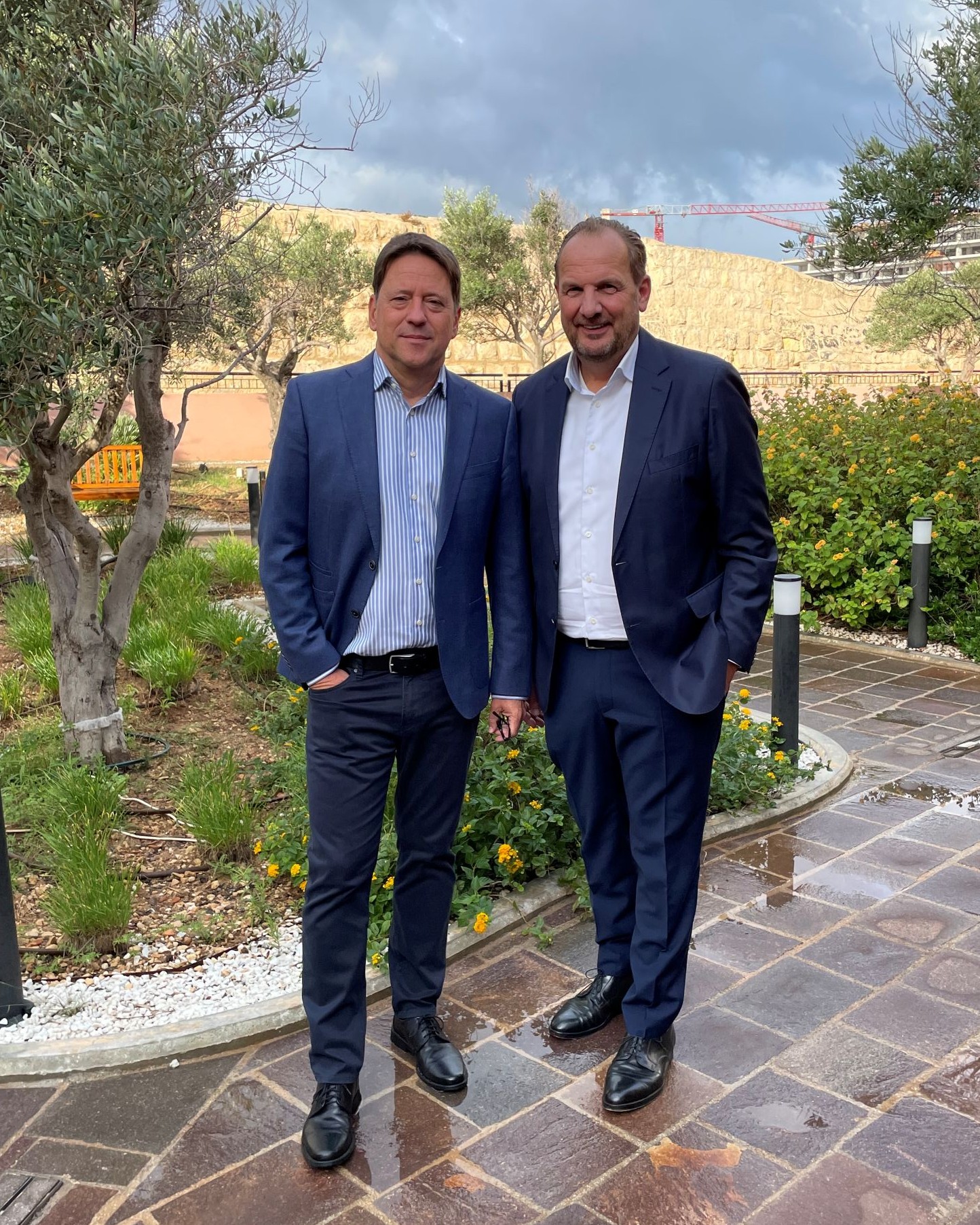 Zwei Männer in dunklen Anzügen lächeln in die Kamera