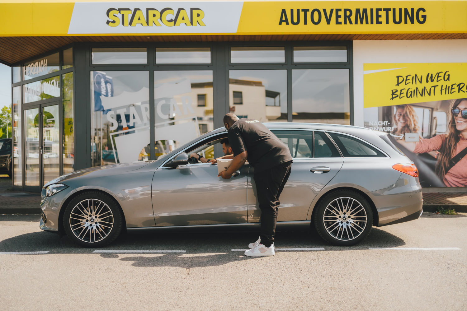 Wie geht es weiter mit Starcar? Das Unternehmen hat Insolvenz angemeldet Eine Station des Autovermieters Starcar in den gelb-weiß-schwarzen Unternehmensfarben. Davor steht ein Mietwagen und ein Mitarbeiter, der einen Kunden auf das Auto einweist.
