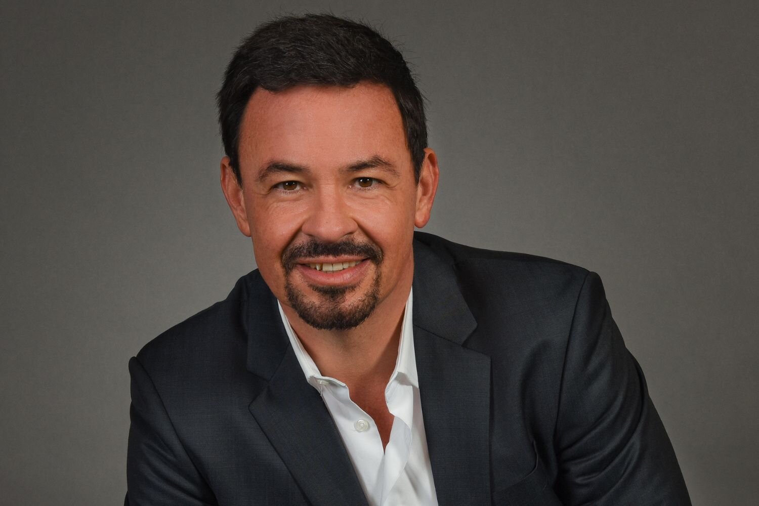 Ein Mann im dunklen Anzug und weißem Hemd, es ist Marcel Mayer vom Reiseveranstalter Berge & Meer.