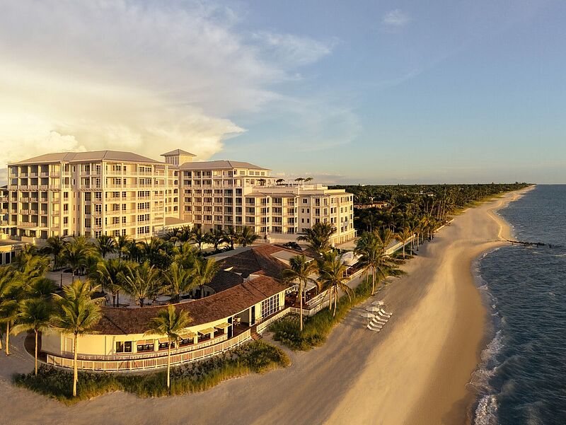 Luxuriöses Strandhotel an der Golfküste mit direkter Lage am feinsandigen Strand, Palmen und Meerblick bei Sonnenuntergang