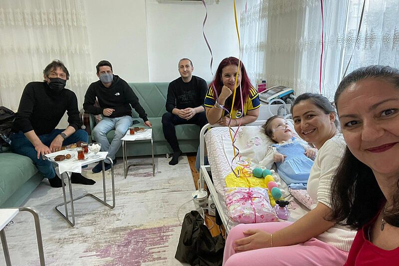 Die Reisebüro-Inhaberin Seval Coskun (vorne rechts) am Krankenbett der kleinen Sare