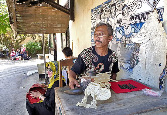 Ein Handwerker fertigt Figuren für das traditionelle Schattentheater.