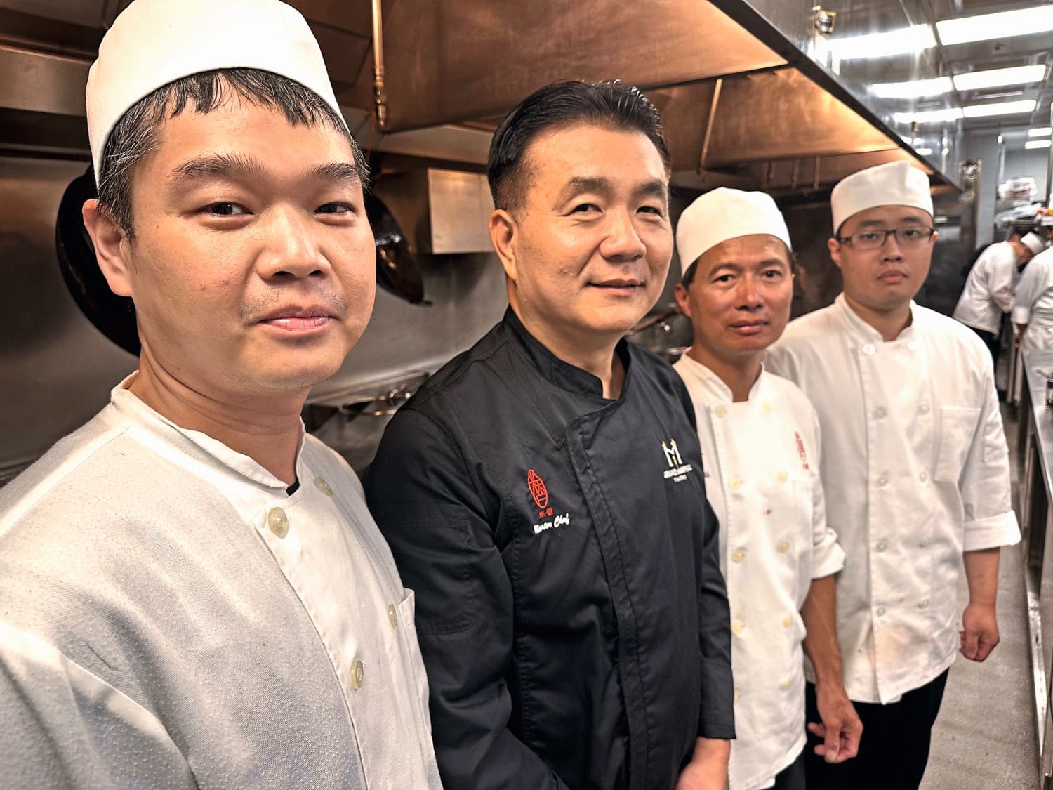 Vier Köche in einer Küche in Kochuniform