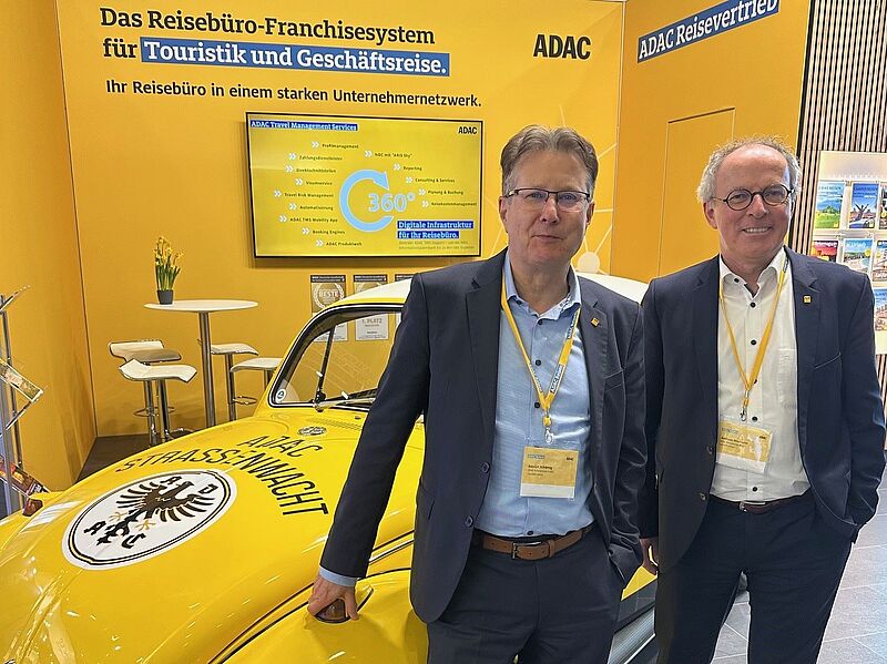 Touristiker vor einem gelben VW-Käfer des ADAC auf der Reisemesse ITB