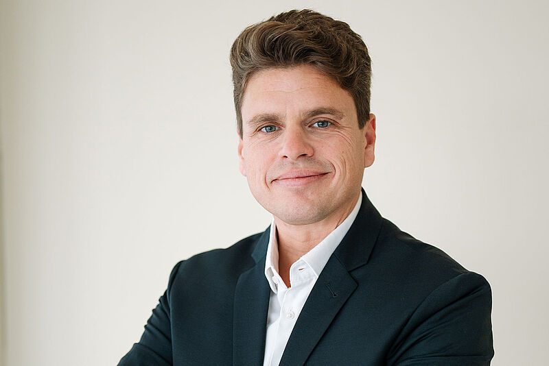 Porträtbild des grinsenden Airline-Managers Sven Pawelka in schwarzem Jackett und weißem Hemd.