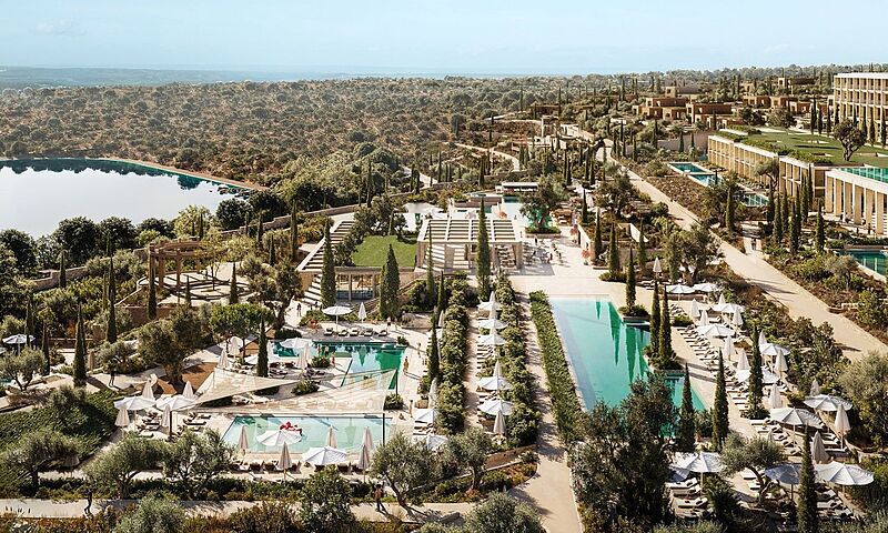Luxuriöses mediterranes Resort mit Panoramaausblick über Olivenhaine, Infinity-Pools und stilvollen Sonnenterrassen an der Küste der griechischen Peloponnes – nachhaltige Architektur Küste der griechischen Peloponnes – nachhaltige Architektur und exklusives Reiseziel für anspruchsvolle Genießer und Wellnessurlauber.