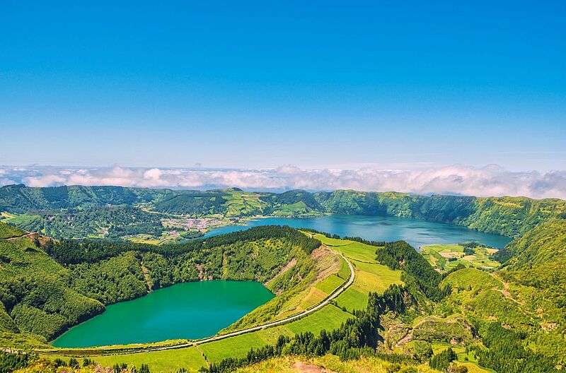 ein grüner Kratersee inmitten von grünen Bergen