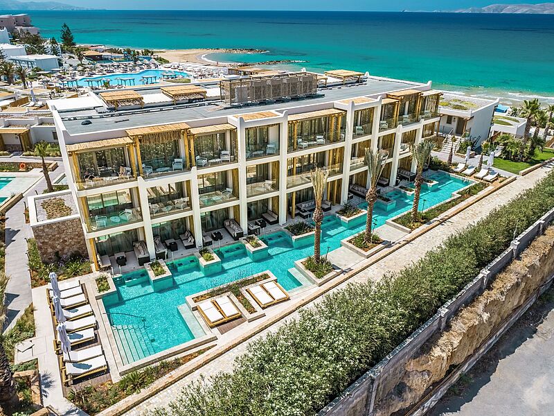 Luxuriöses Strandhotel auf Kreta mit modernen Suiten, privaten Pools, Sonnenliegen und direkter Lage am türkisblauen Meer – perfektes Reiseziel für Sommerurlaub 2026