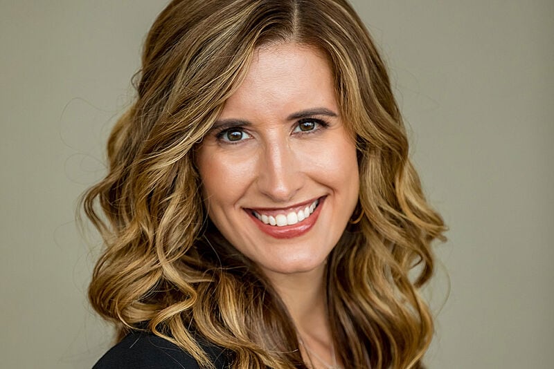 Porträtfoto von Leah Chandler, einer lachenden Frau mit langen, lockigen Haaren