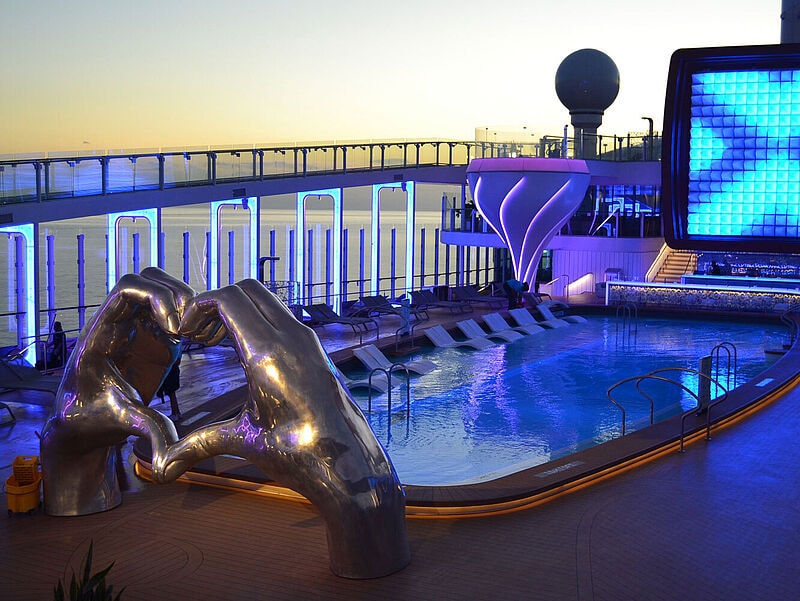 Pool auf bunt beleuchtetem Kreuzfahrtschiff