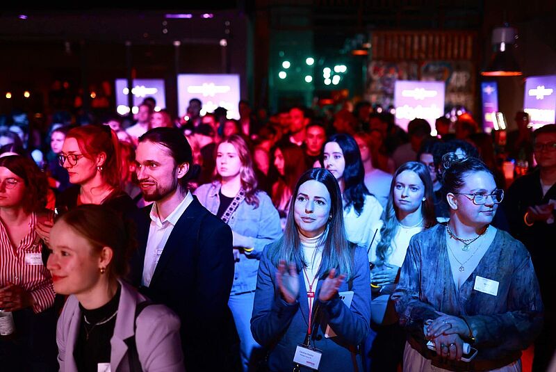Junge Menschen bei einer Abendveranstaltung in einer Halle