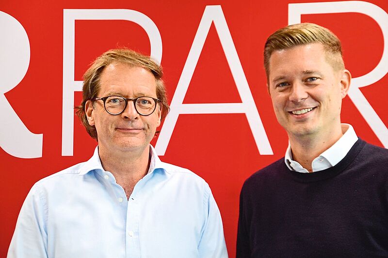 Zwei Männer vor einer roten Wand