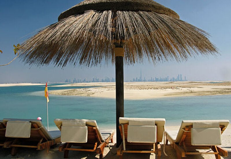 Brachland: Blick vom ersten Beachclub auf dem Inselprojekt „The World“, im Hintergrund die Skyline von Dubai. Foto: hs