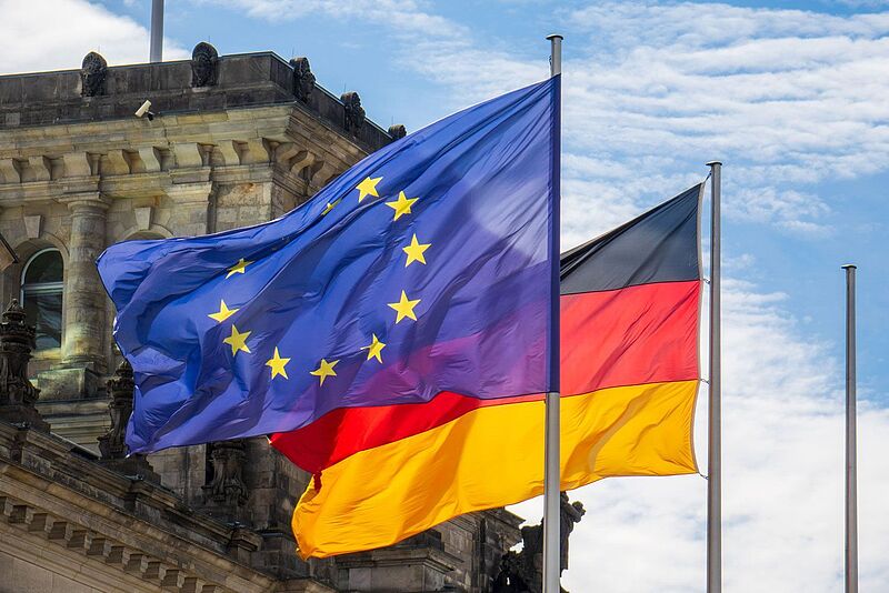 Vor dem Deutschen Bundestag in Berlin wegen die blau-gelbe Europa-Flagge und die schwarz-rot-goldene Deutschland-Fahne.