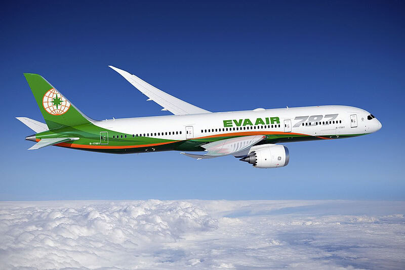 Ein Flugzeug von Eva Air über den Wolken vor blauem Himmel