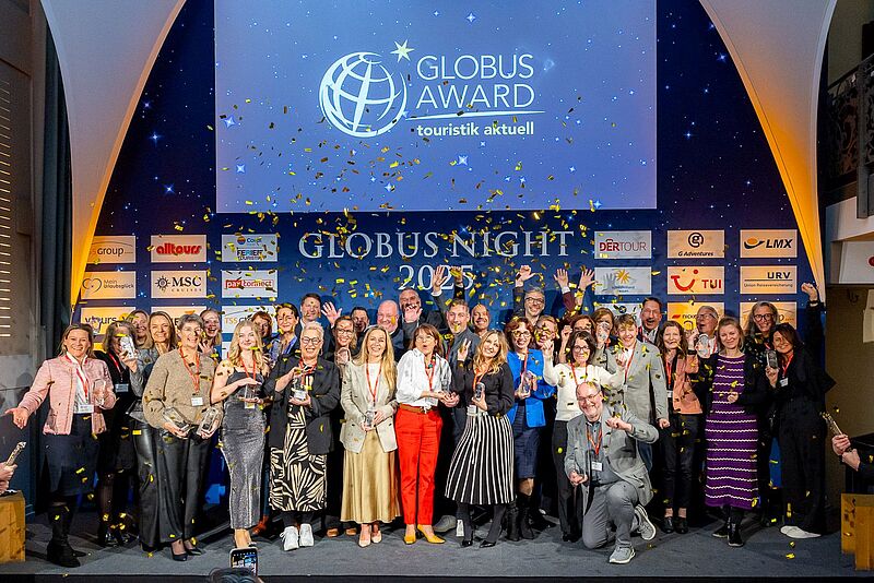 Viele Menschen auf einer Bühne vor goldenem Konfettiregen