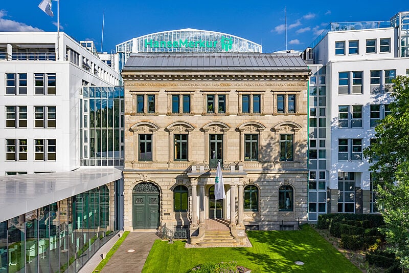 Ein altes Firmengebäude umgeben von modernen Gebäuden