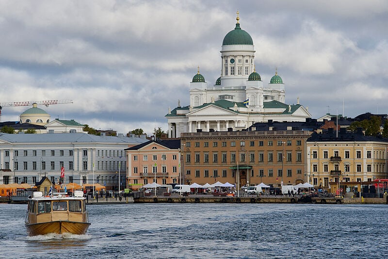 Blick auf klassizistische Gebäude von Helsinki vom Wasser aus gesehen bei grauem Himmel
