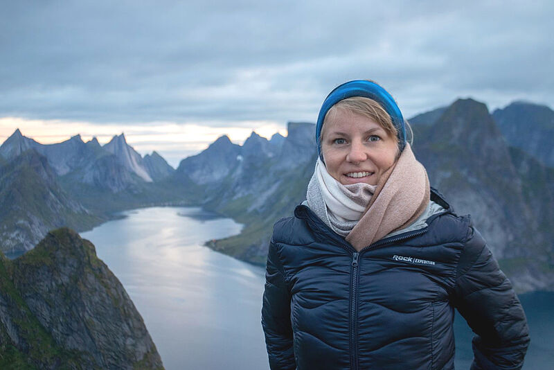 Die neue Hurtigruten-Mitarbeiterin Jennifer Klatt vor norwegischer Fjordlandschaft