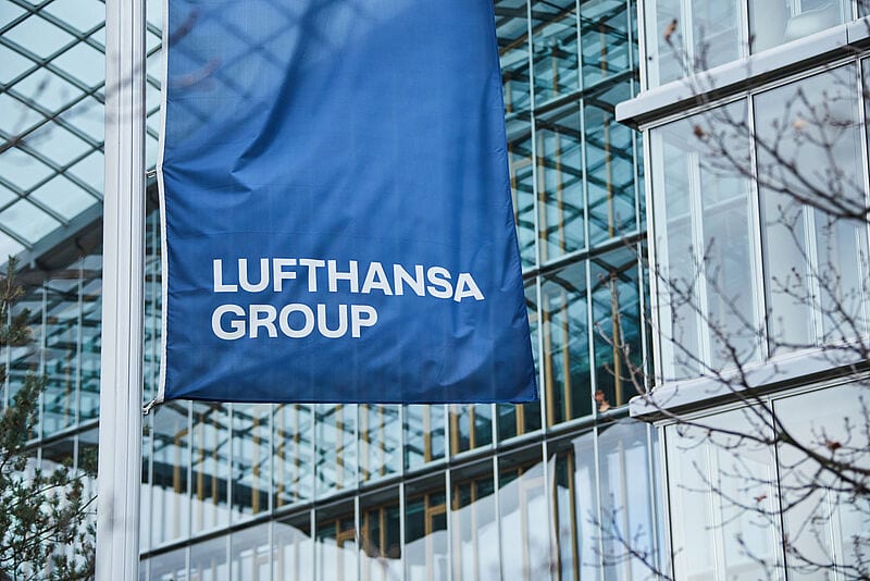 Eine blaue Flagge mit Lufhansa-Schriftzug weht vor der Konzernzentrale der Airline-Gruppe
