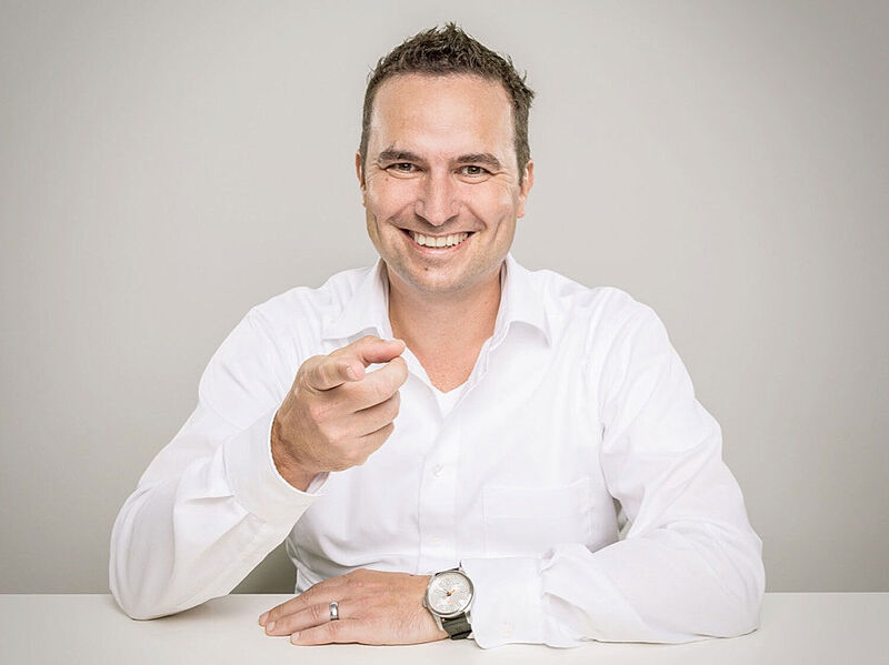 Mann mit weißem Hemd an Schreibtisch