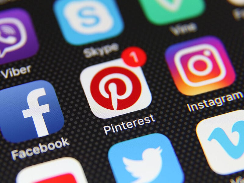 Auf einem schwarzen Smartphone-Hintergrund sind Apps wie Facebook, Instagram und Pinterest abgebildet. Bei dem Pinterest-Icon ist eine Benachrichtigung in Form der Ziffer 1 zu sehen.