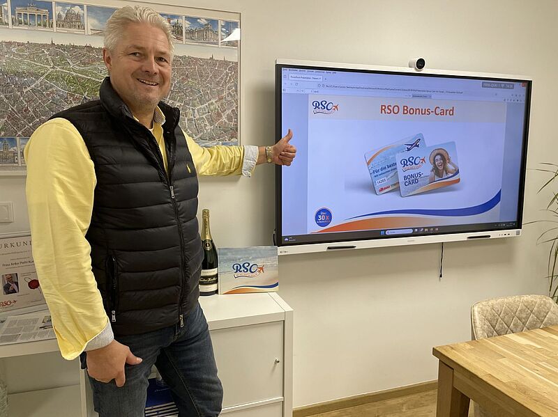 Carsten Seelmeyer zeigt auf einen Bildschirm auf dem das Konzept Bonus-Card gezeigt wird