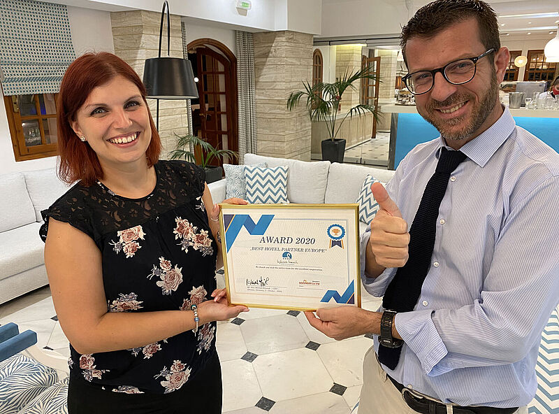 Überreichte die Auszeichnung persönlich auf Kreta: Büroleitern Julia Mühlbach mit Vasilis Tsamandouras, Geschäftsführer des Kyknos Beach