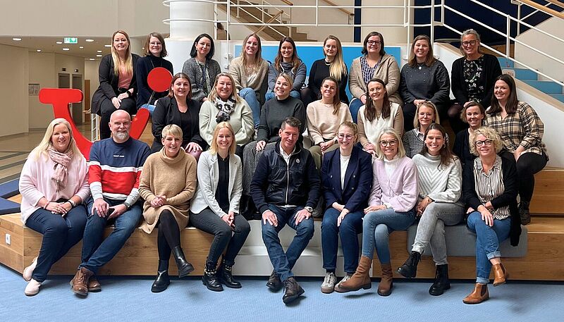 Ein Gruppenfoto mit vielen sitzenden Menschen