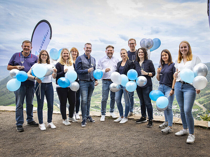 Touristiker-Gruppe mit Luftballons vor Himmel 