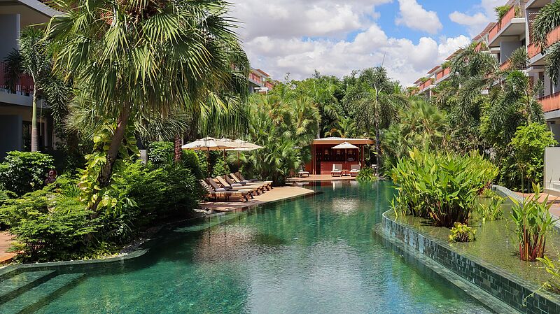 Luxuriöser Hotelpool im TUI Blue Angkor Grace in Kambodscha, umgeben von tropischen Palmen, Sonnenliegen und moderner Architektur – perfekte Oase für Erholung und Wellnessurlaub.