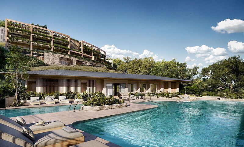 Ein mehrstöckiges Gebäude erhebt sich hinter einem Pool