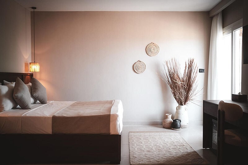 Modernes Hotelzimmer in Hurghada, Ägypten im Boho-Design, gemütlichem Doppelbett, natürlicher Dekoration und hellem Tageslicht 