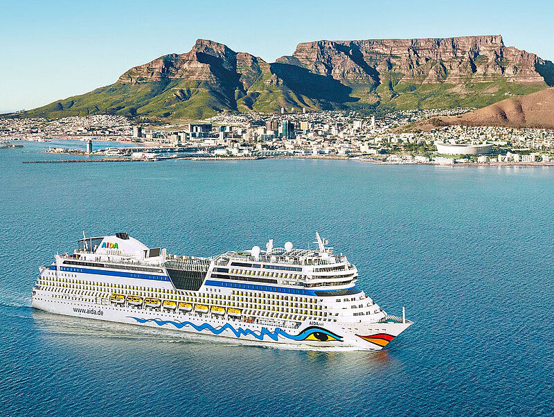 Kreuzfahrtschiff fährt vor der Kulisse Kapstadts mit Tafelberg