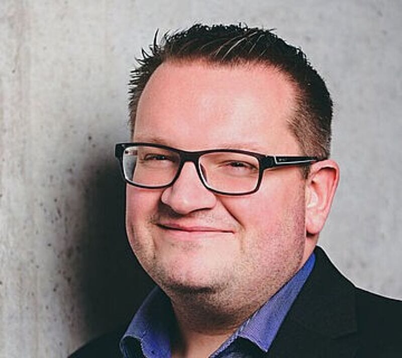 Ein lächelnder Mann mit Brille