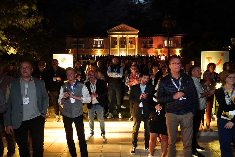 Viele Menschen im Dunkeln vor einer Villa