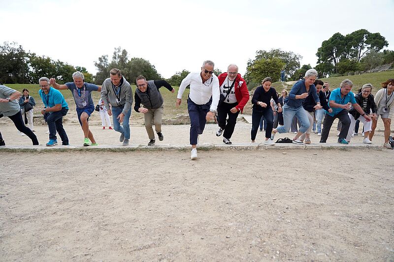 Menschen rennen über eine sandige Strecke
