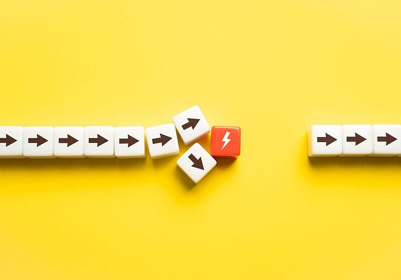 Kleine Holzklötze mit Pfeilen auf gelbem Hintergrund